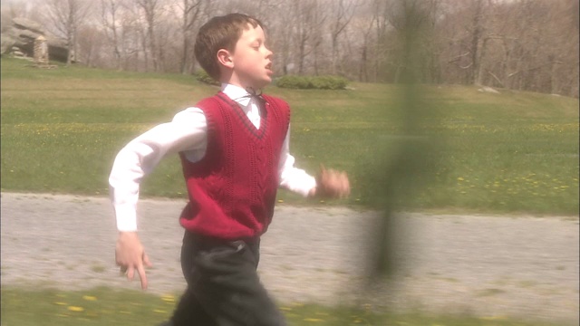 一个男孩在玉米地旁边跑。视频素材