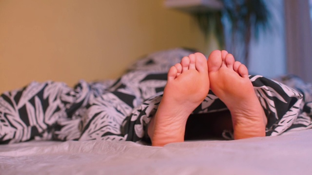 一个躺在床上的女人的腿的特写。视频素材