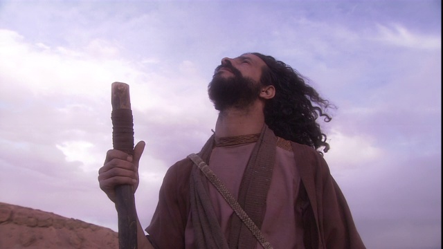 一个满脸胡须的人注视着沙漠的天空。视频下载
