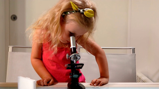 可爱的小女孩透过显微镜看东西视频下载