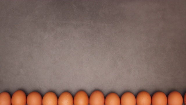 鸡蛋在黑暗背景的底部移动-停止运动视频下载