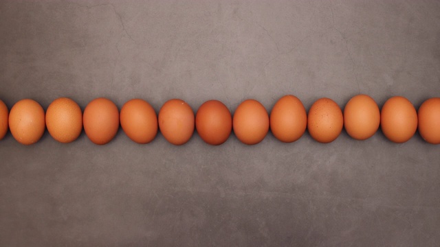 鸡蛋滚动在黑暗的背景-循环定格动画视频下载