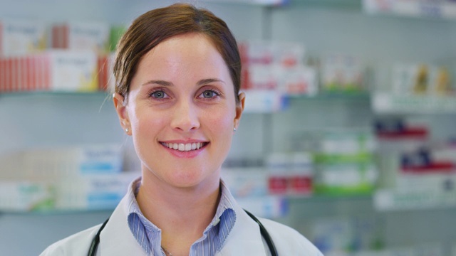 一个美丽的年轻女性药剂师顾问展示了一个装有药丸的瓶子和微笑的慢镜头视频素材
