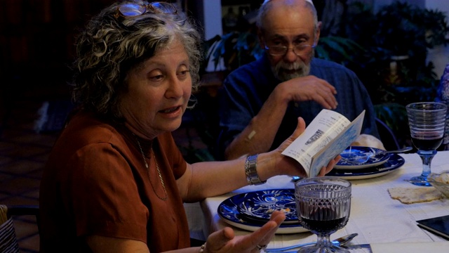 一位犹太妇女坐在桌子旁讲着一本书里的故事视频素材