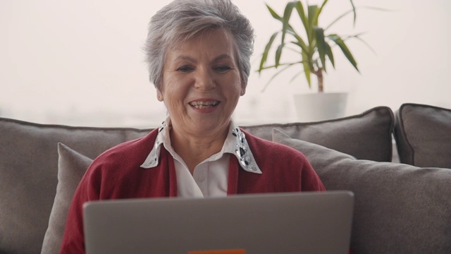快乐的退休妇女用现代技术和家人视频聊天视频素材