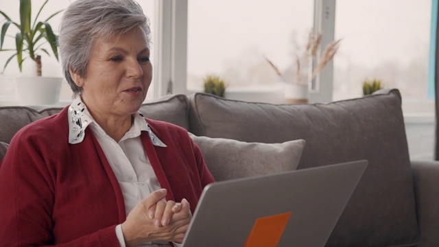 退休的祖母在笔记本电脑上和孙子聊天视频素材
