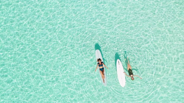 两个女人在泻湖上玩桨板视频素材