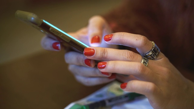 女人的手在桌子上使用手机的特写视频下载