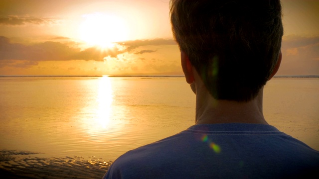 手握在一个人的肩上，看着大海上的日落视频素材