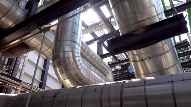 蒸汽金属管道的保温，标签塞和阀门在电厂的平移视图视频素材