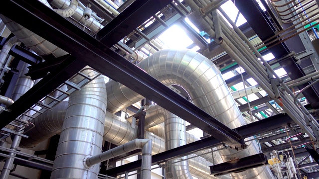 蒸汽金属管道的保温，标签塞和阀门在电厂的平移视图视频素材
