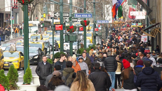 2020年1月2日，美国纽约，冬季假期期间，一群人沿着人行道和曼哈顿中城拥挤的交通穿过第五大道。视频下载