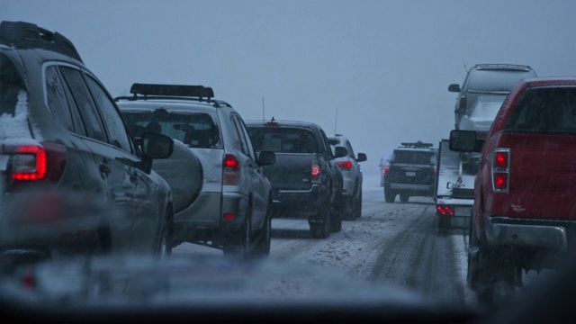 黄昏时分，暴风雪期间，在州际公路上被事故和紧急救援人员拦下时，从一辆车的前面拍摄的视频下载