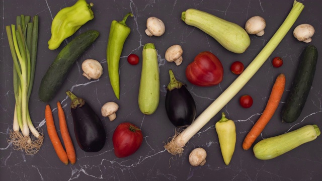 有机和新鲜蔬菜在黑色大理石背景-停止运动视频下载