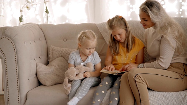 在现代室内和孩子们一起读书的女人视频素材
