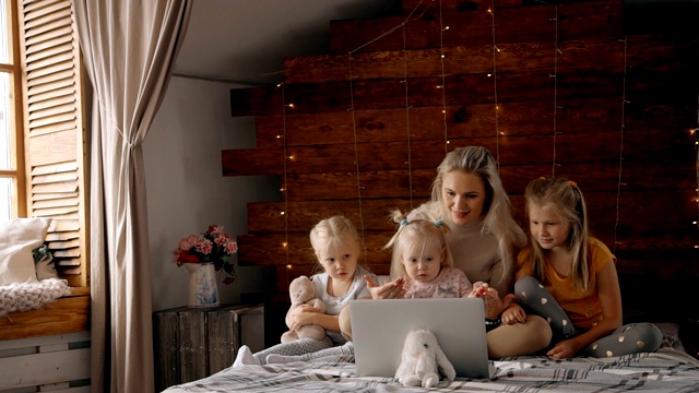 妈妈和她的孩子在家里使用笔记本电脑视频下载