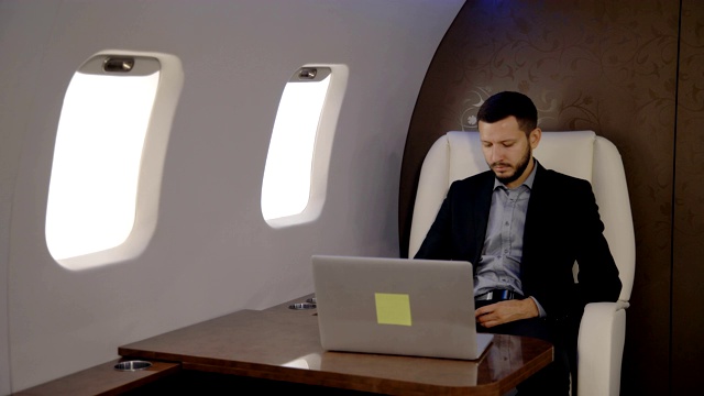 年轻的首席银行家董事商人在私人飞机上用笔记本电脑工作视频下载