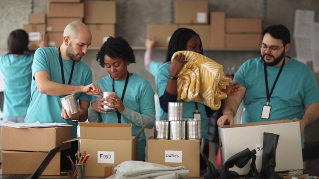 不同的志愿者在慈善食品银行包装捐赠箱视频下载