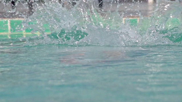 亚洲男子跳进游泳池视频素材