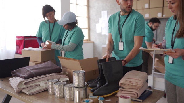 不同的志愿者在慈善食品银行包装捐赠箱视频下载
