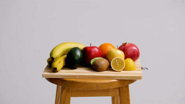 白底的木凳上放着新鲜的水果视频下载