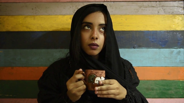 年轻美丽的穆斯林女孩戴着头巾，拿着陶器茶杯视频下载