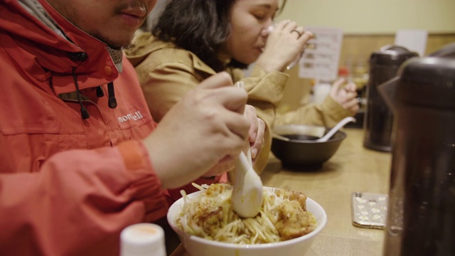 年轻的亚洲夫妇在餐厅吃拉面。视频下载