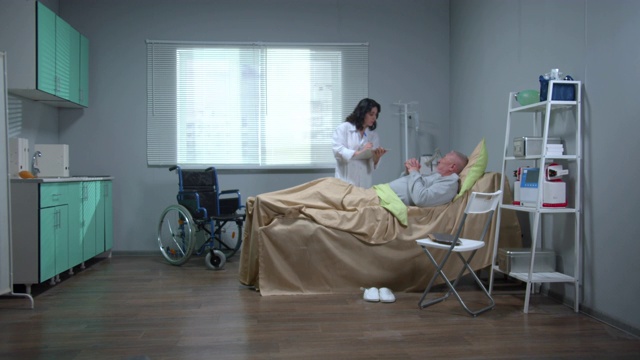 医生与躺在医院病床上的病人交谈视频素材