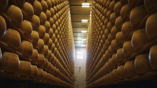 慢动作滑块的观点，许多车轮帕尔马干酪是成熟的古老的意大利传统仓库货架上好几个月视频购买