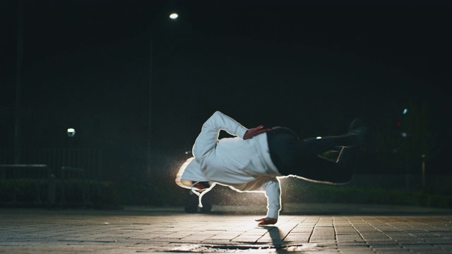 慢动作的年轻的霹雳舞者是有乐趣跳舞与汽车在城市停车场晚上视频下载