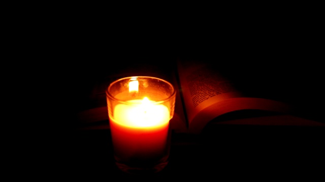 黑暗中的烛光《圣经》作为背景视频素材