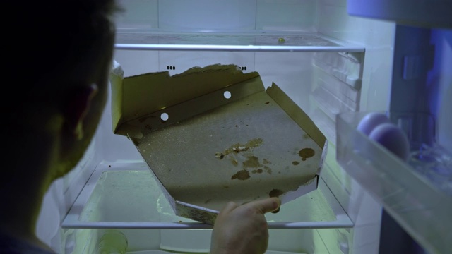 在冰箱里找食物的人。一个没刮胡子的家伙打开冰箱门，发现里面有一个空披萨盒。视频下载