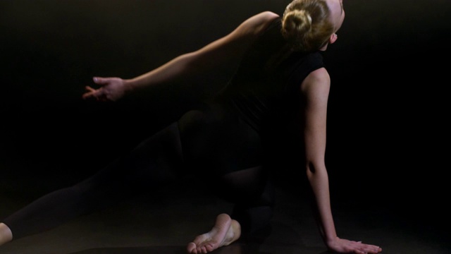 年轻漂亮的女舞者在黑暗的工作室视频下载