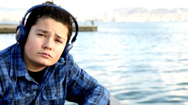 一个悲伤的少年独自在海边的肖像视频下载