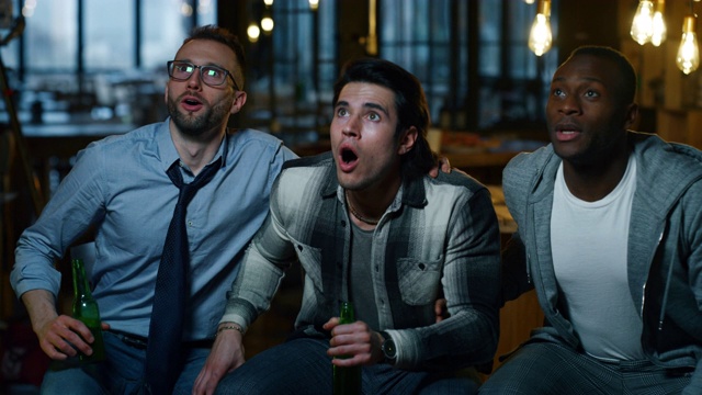 三个快乐的大学朋友一起在酒吧喝啤酒欢呼的慢镜头视频素材