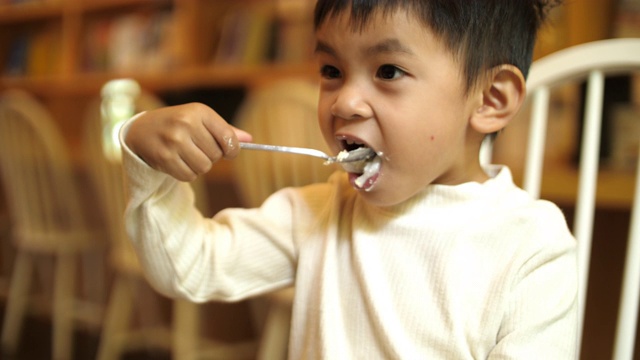 亚洲小男孩在咖啡厅吃蛋糕视频素材
