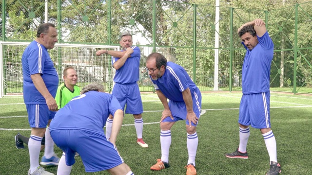 老年男子足球队穿着蓝色制服热身比赛前锻炼视频素材