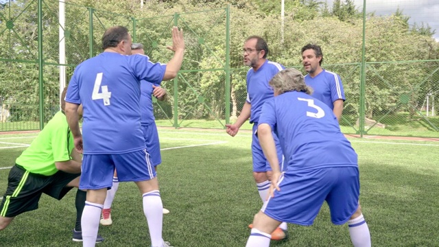 老年男子足球队穿着蓝色制服热身比赛前锻炼视频素材