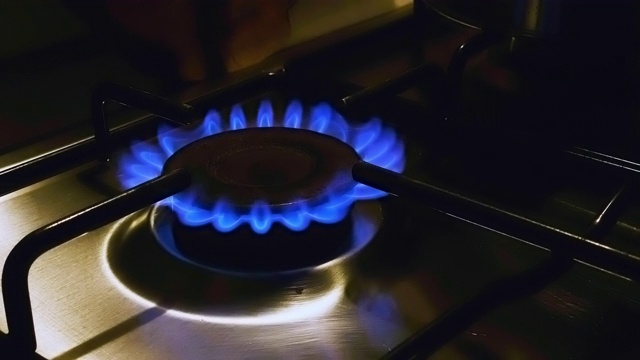 近距离观看的蓝色火焰的炉灶，在一个家庭厨房在低光视频素材