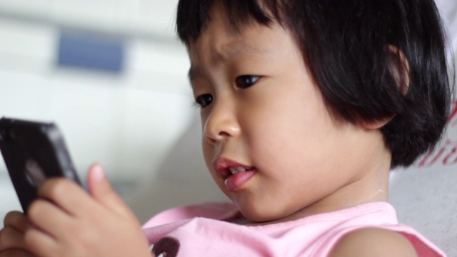亚洲小女孩在家里用智能手机视频素材