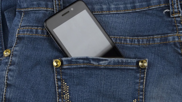 变焦。智能手机从牛仔裤后口袋里伸出来。商业和时尚视频素材