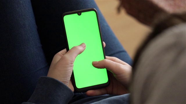 女人使用智能手机的特写，绿色屏幕视频下载