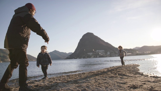 日落时分，孩子们在湖边投入父亲的怀抱视频素材