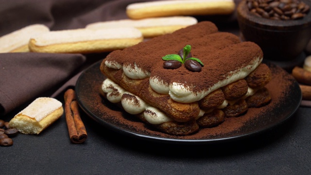 陶瓷盘子上的经典提拉米苏甜点，混凝土背景上的savoiardi饼干视频下载