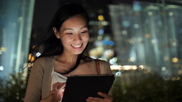 亚洲女性在晚上使用数字平板电脑视频下载