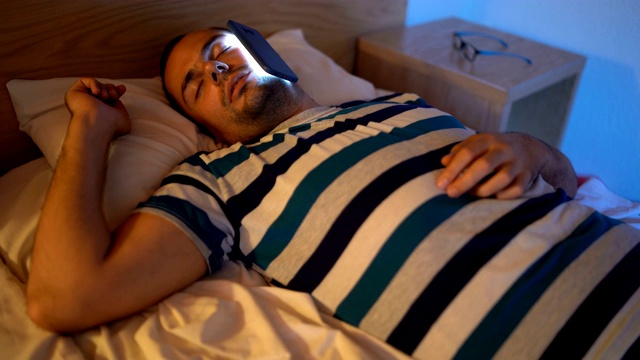 一个脸贴着手机睡着的男人视频素材