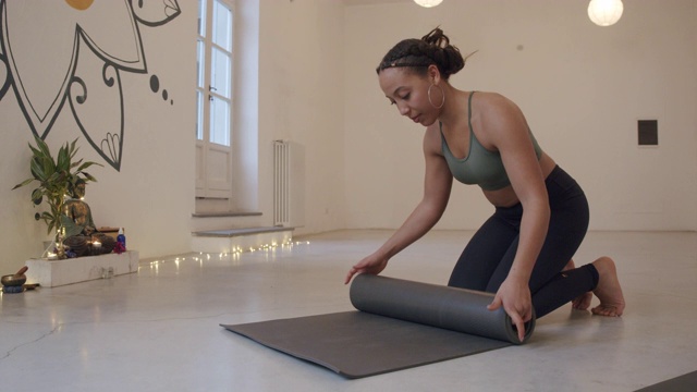 一名年轻成年女子合上瑜伽垫的慢动作视频视频下载