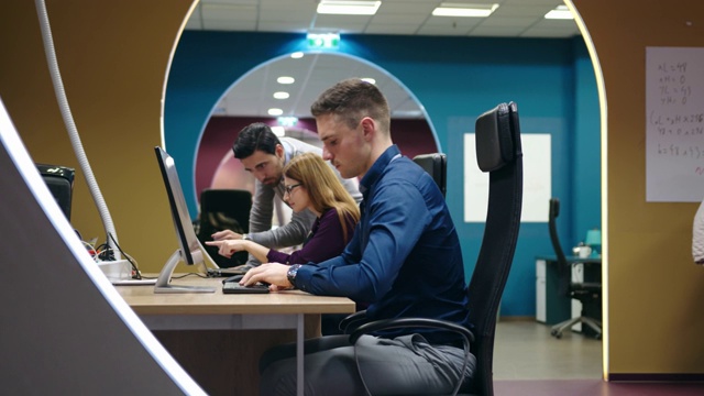 一群电脑程序员坐在办公桌前用电脑工作视频素材