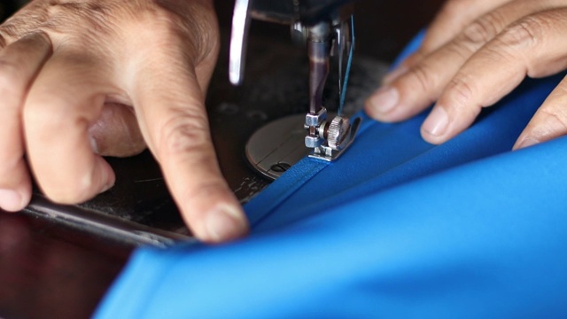 用旧缝纫机手工缝制蓝色织物。视频下载