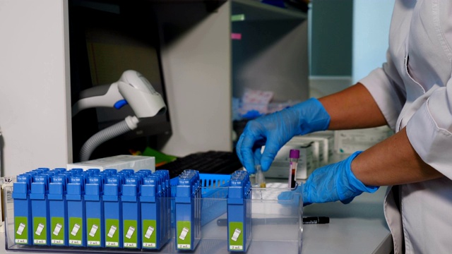 现代实验室工作人员将血液样本放在架子上。专家在特殊设备上进行血液和dna检测。在4 k拍摄视频素材